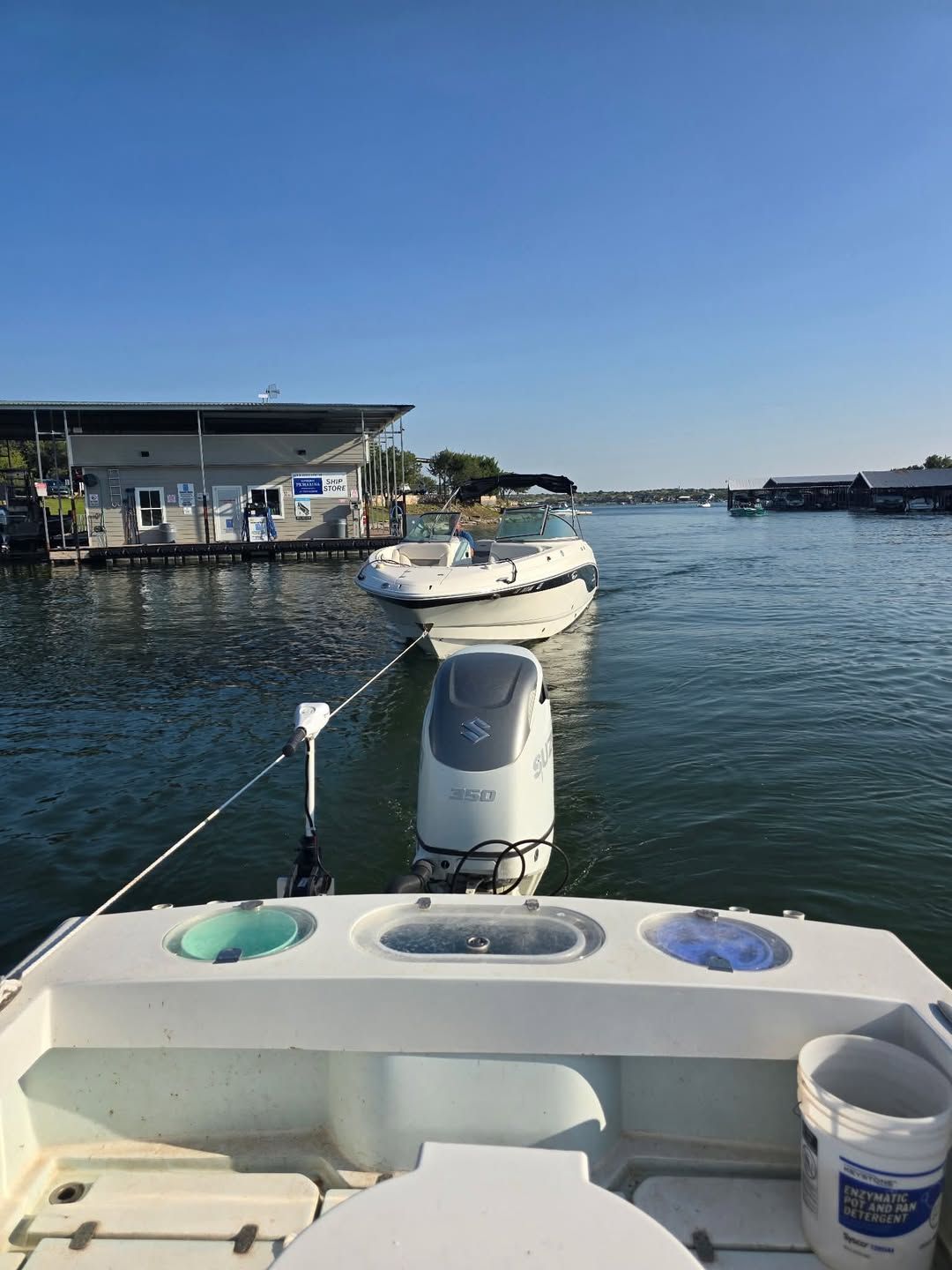 A white boat docked at the TowBoat Possum Kingdom Lake waterfront, service building behind it.